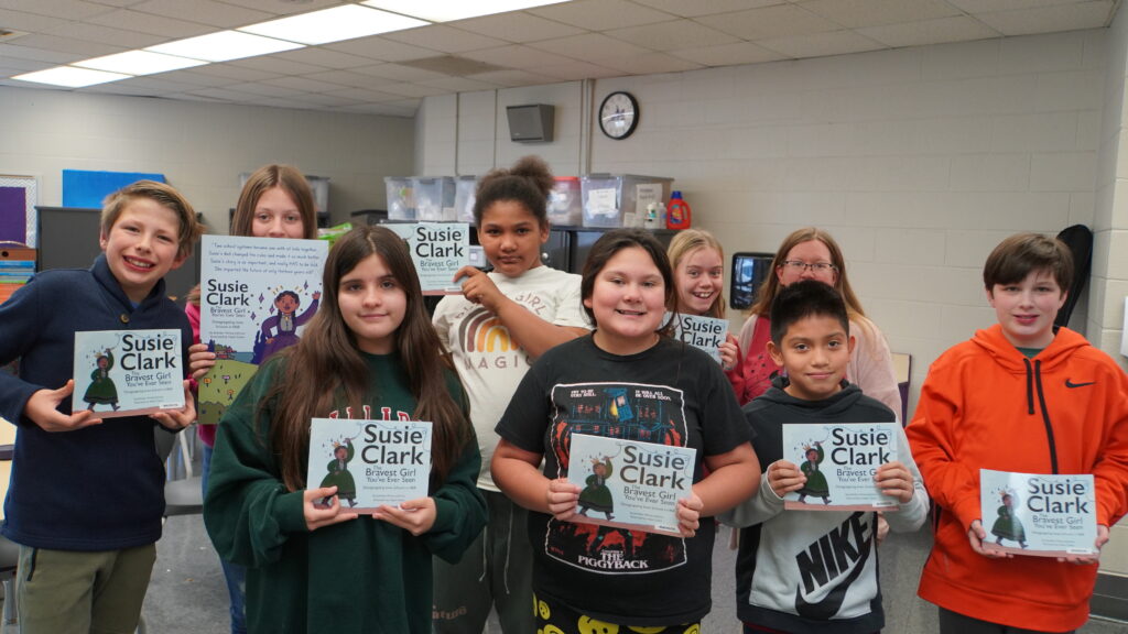 Group of students holding copies of the Susie Clark book